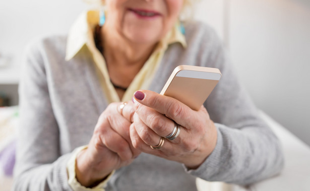 Starsza kobieta używa telefonu