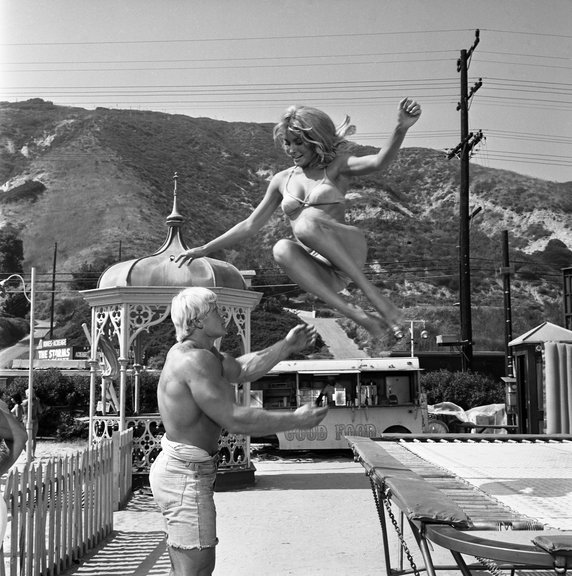 Sharon Tate zeskakująca z trampoliny w ramiona Davida Drapera na planie filmu "Don't Make Waves" w 1966 r.