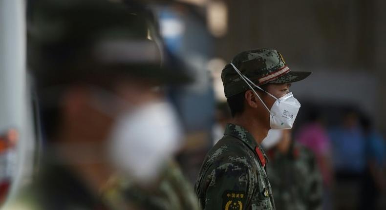 Paramilitary police wearing face masks stand guard near the site of an explosion in Tianjin, in northern China, on August 13, 2015