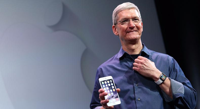 Apple CEO Tim Cook holding one of the company's iPhones.