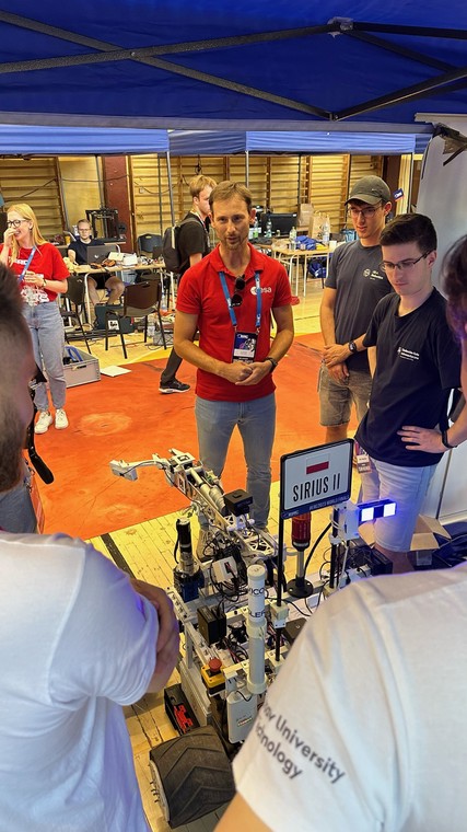 Sławosz Uznański ogląda łazik "Sirius II" studentów Politechniki Warszawskiej podczas zawodów European Rover Challenge w Kielcach, 16 września 2023 r.