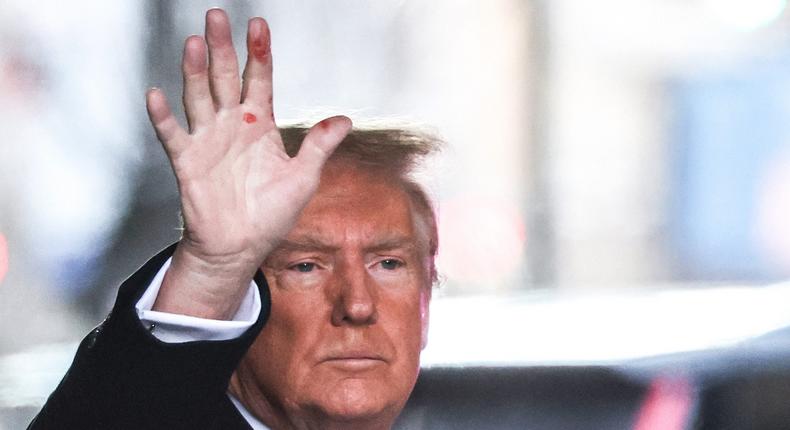 Former President Donald Trump waves to the crowd outside Trump Tower on Tuesday. Red marks are clearly visible on his hand.Charly Triballeau/AFP/Getty Images