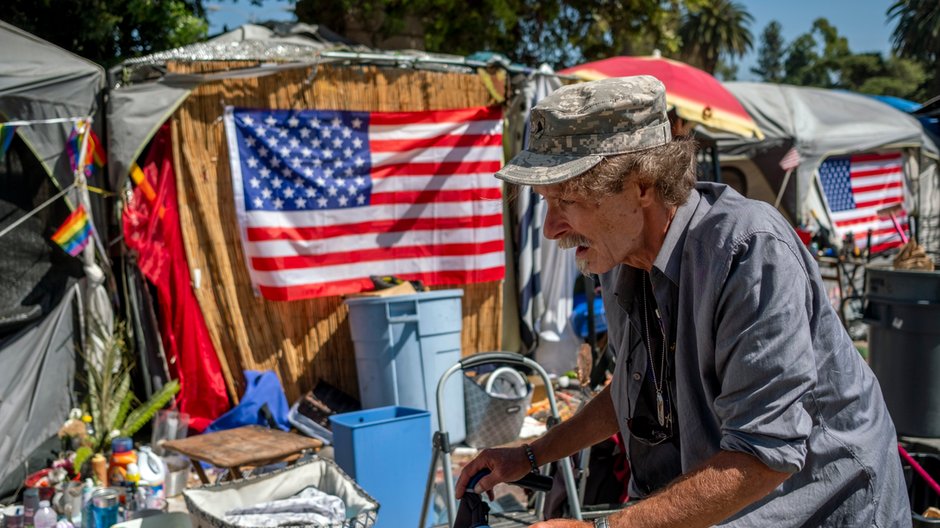 Douglas Bue, lat 65, pcha swój wózek inwalidzki do obozowiska bezdomnych w Los Angeles, 2021 r.