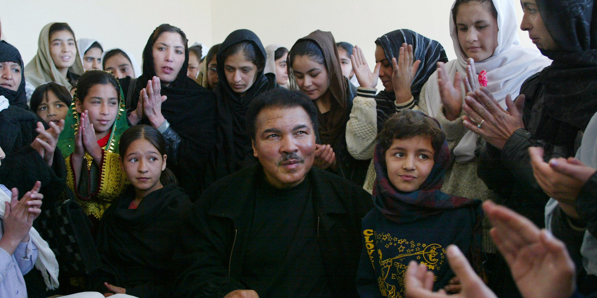 Former world heavyweight boxing champion Muhammad Ali, center, sits with Afghan students during his visit to Karte Sei High school for Girls, November 18, 2002, in Kabul, Afghanistan. Ali died on June 3 at the age of 74.