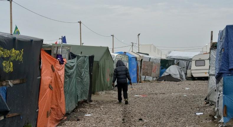 A migrant walks in the Jungle camp in Calais, northern France, early on October 24, 2016