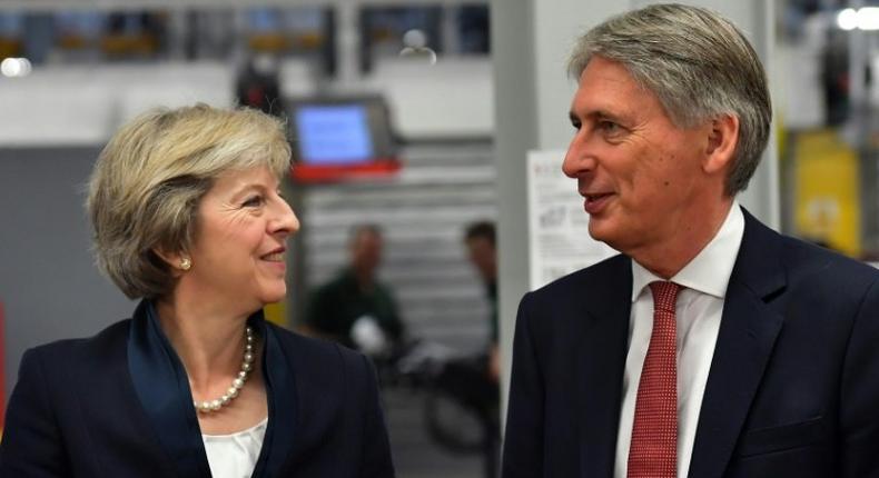 British Prime Minister Theresa May (left) speaks with Chancellor of the Exchequer Philip Hammond during a visit to the Jaguar Land Rover factory in Solihull, on September 1, 2016