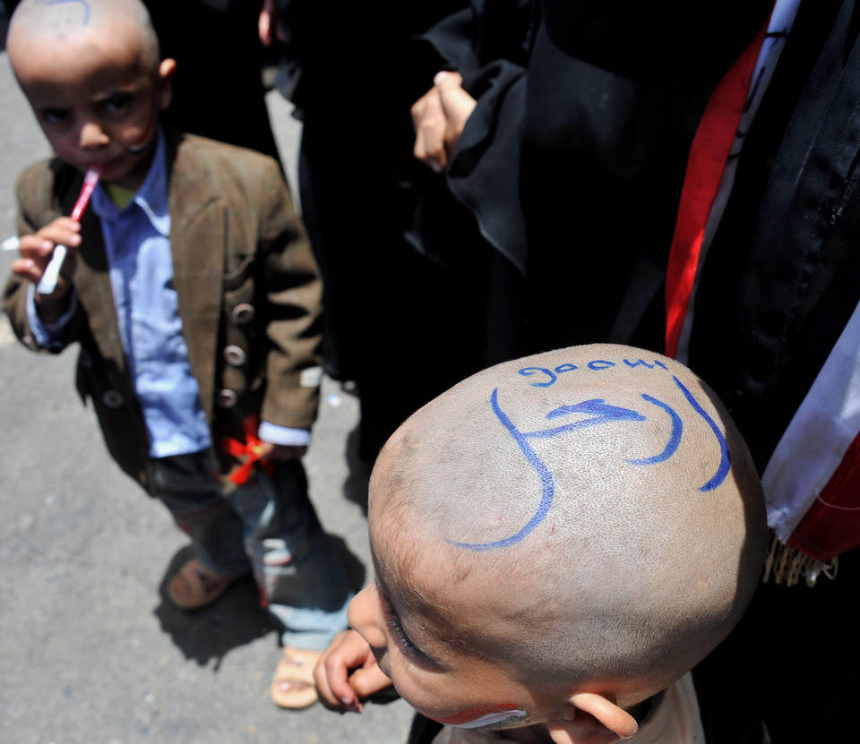 Dzieci z napisami na głowach w języku arabskim "Idź precz!" uzestniczące w antyrządowym proteście w Jemenie