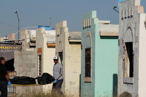 Forensic technicians remove a body from a crime scene where unidentified assailants killed and injured people living in a house at Riberas del Bravo neighbourhood, in Ciudad Juarez