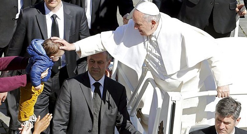 The Pope blesses a baby at the end of Palm Sunday Mass 