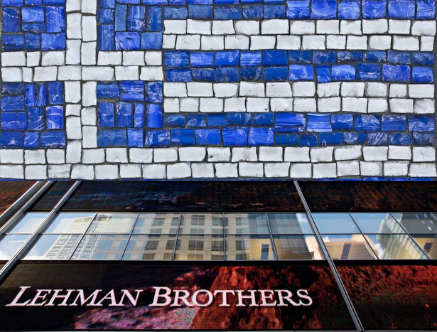 Flaga Grecji i logo upadłego banku Lehman Brothers, źródło: Shutterstock, Bloomberg