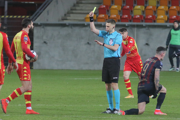 Zawodnik Jagiellonii Białystok Błażej Augustyn (L) ukarany żółtą przez sędziego głównego Damiana Sylwestrzaka (2P) podczas meczu 21. kolejki piłkarskiej Ekstraklasy z Pogonią Szczecin