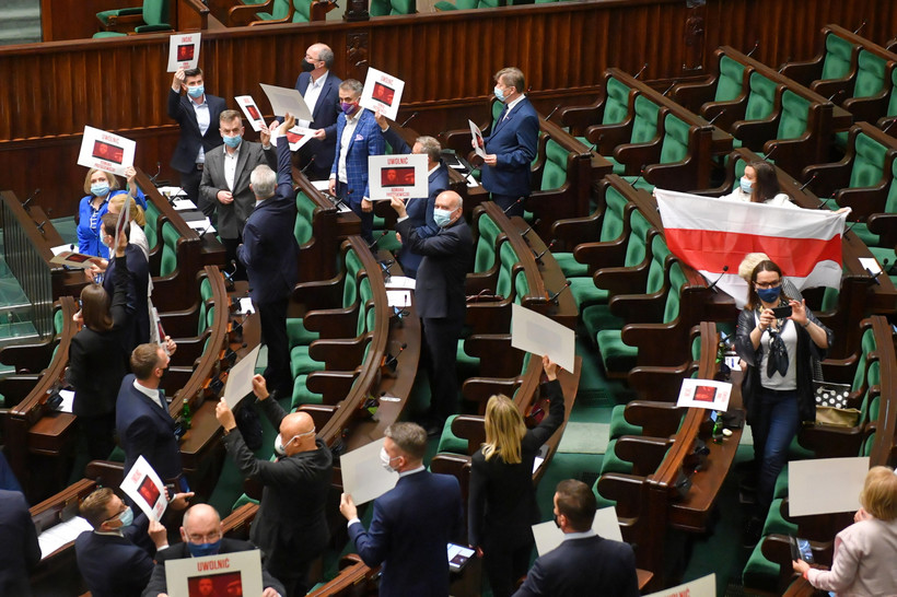 Podczas odczytania treści uchwały posłowie KO trzymali plansze z wezwaniem Uwolnić Ramana Pratasiewicza oraz wykorzystywane przez białoruską opozycję biało-czerwono-białe flagi narodowe.