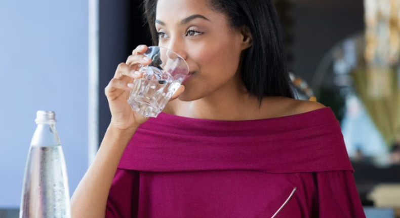 Lady drinking while eating