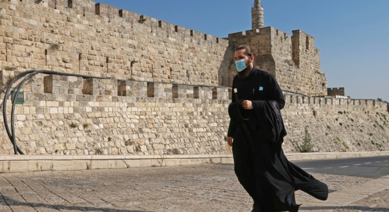 A priest, wearing a protective mask amid the Covid-19 pandemic, walks along the walls of Jerusalem's Old City on September 12, 2020