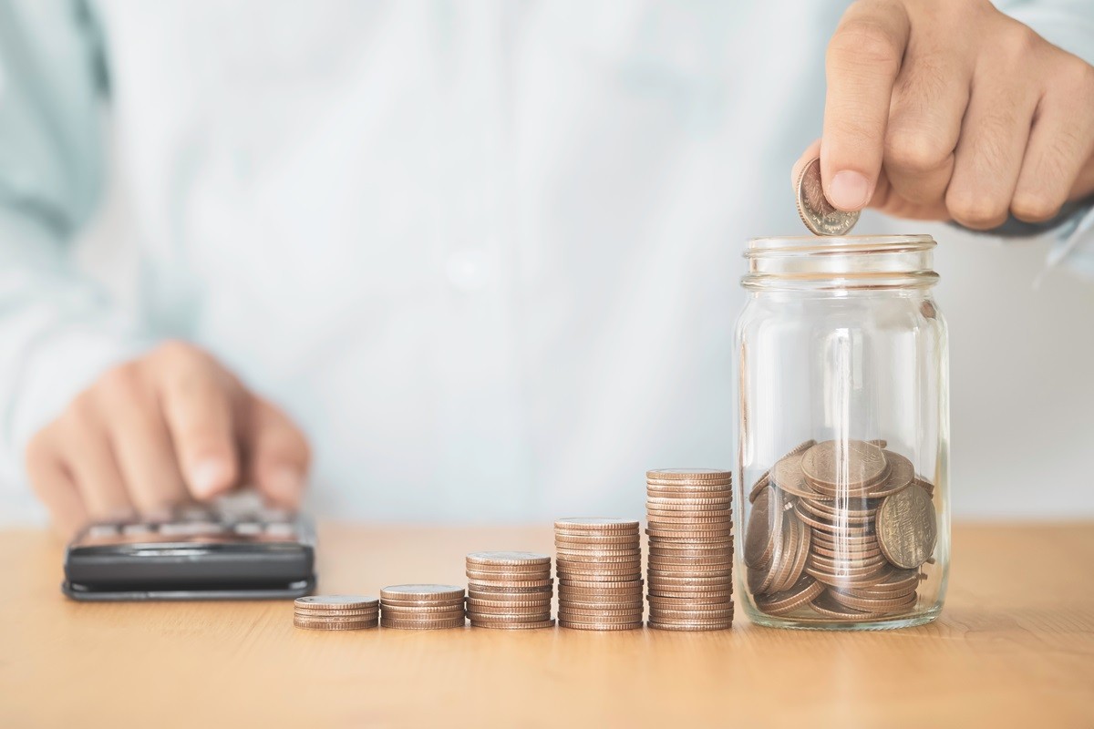 Mężczyzna wrzucający monety do słoika