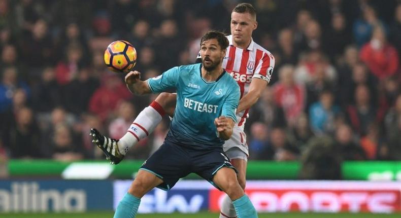 Swansea City's striker Fernando Llorente (L) vies with Stoke City's defender Ryan Shawcross during the English Premier League football match October 31, 2016