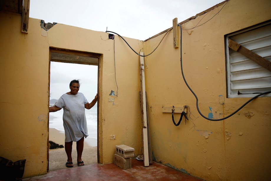 Irma Torres stands in the doorway of her roofless home after Hurricane Maria in Yabucoa, Puerto Rico.