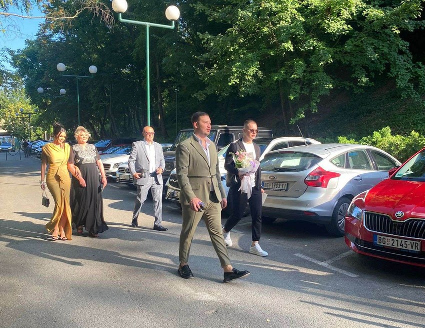 Devojka Uroša Živkbića (kroz levo) u narandžastojj haljini sa njegovom majkom