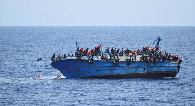 Migrants are seen on a capsizing boat before a rescue operation by Italian navy ships Bettica and Bergamini (unseen) off the coast of Libya in this handout picture released by the Italian Marina Militare on May 25, 2016. 