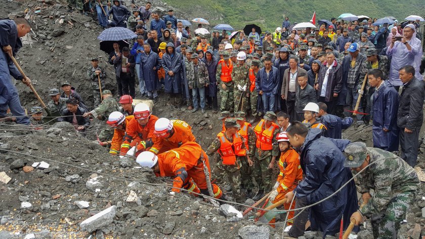 People search for survivors at the site of a landslide that occurred in Xinmo Village