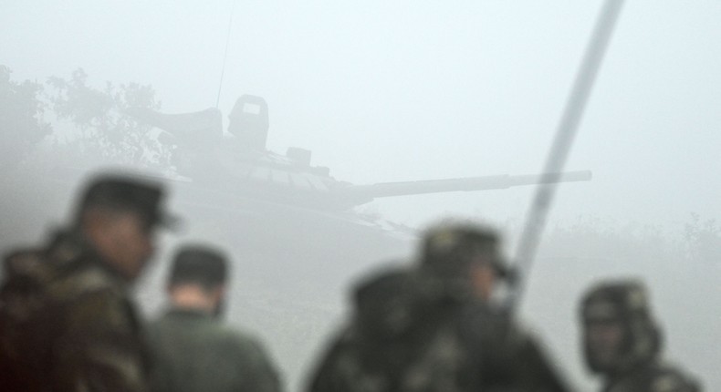 Servicemen stand in front of a tank during the 'Vostok-2022' military exercises at the Sergeevskyi training ground outside the city of Ussuriysk on the Russian Far East on September 6, 2022.