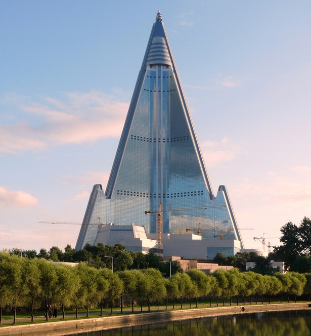 Budynek przedstawiony na zdjęciu to hotel Ryugyong. Liczący 330 metrów i 105 pięter gmach jest największym budynkiem w kraju. Jego budowa rozpoczęła się w 1987 roku, jednak w 1992 roku przerwano ją na szesnaście lat. W 2008 roku budowę wznowiono i władze twierdzą, że hotel zostanie ukończony w tym roku.