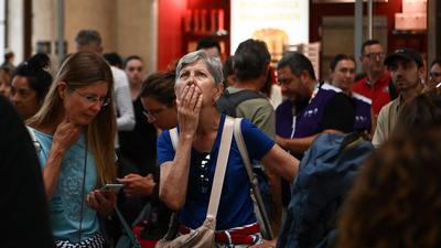 A woman looks at an information screen as passengers wait for their train departures at the Bordeaux-Saint-Jean train station in Bordeaux, western France on July 26, 2024.CHRISTOPHE ARCHAMBAULT