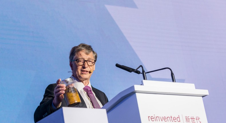 Bill Gates holds up a beaker of human feces at the Reinvented Toilet Expo in Beijing on November 6, 2018.