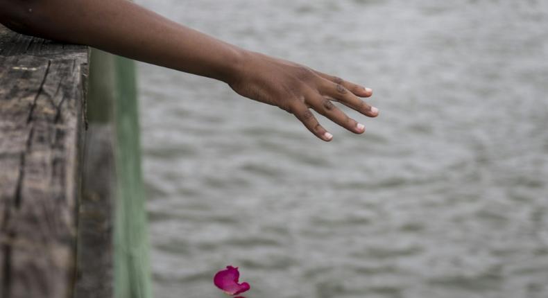 Guests take part in a flower petal throwing ceremony to honor Africans who passed away at sea during the Atlantic slave trade during the 2019 African Landing Commemorative Ceremony on August 24, 2019 in Hampton, Virginia