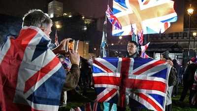 A Brexit supporter poses for a photograph with a Union flag as he waits for the festivities to begin [Study International]
