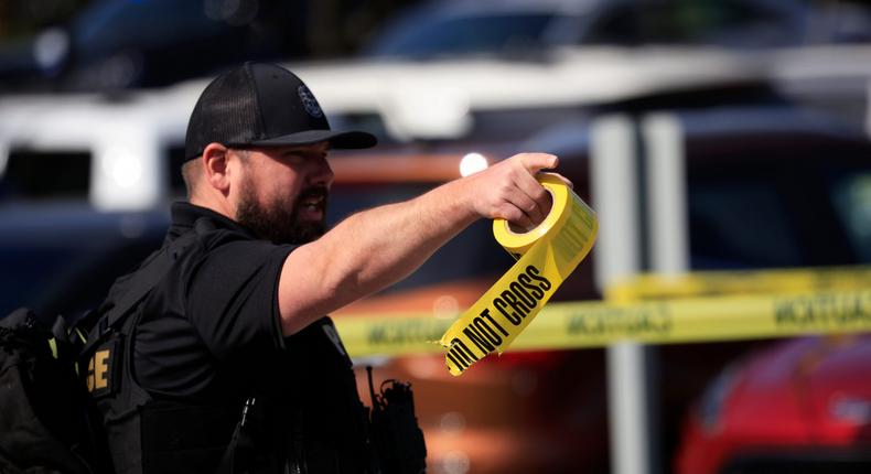 A police officer holds crime scene tape at the scene of the Louisville mass shooting.Luke Sharrett/Getty Images