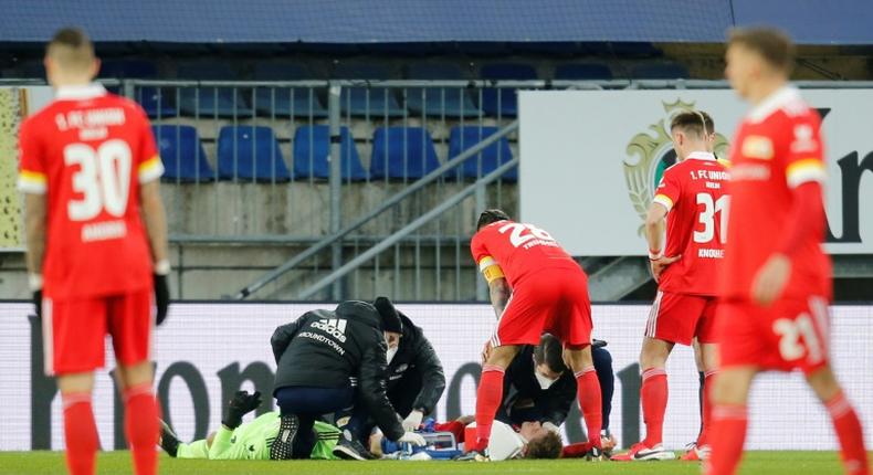 Worrying moment: Union Berlin goalkeeper Andreas Luthe and defender Julian Ryerson receive medical attention