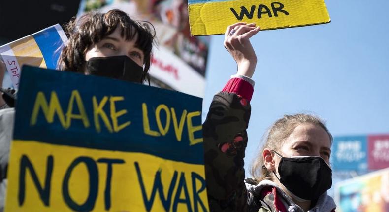 People hold placards as they gather at Tokyo's Shibuya area to protest Russia's invasion of Ukraine, on February 26, 2022. (Photo by Charly TRIBALLEAU / AFP) (Photo by CHARLY TRIBALLEAU/AFP via Getty Images)