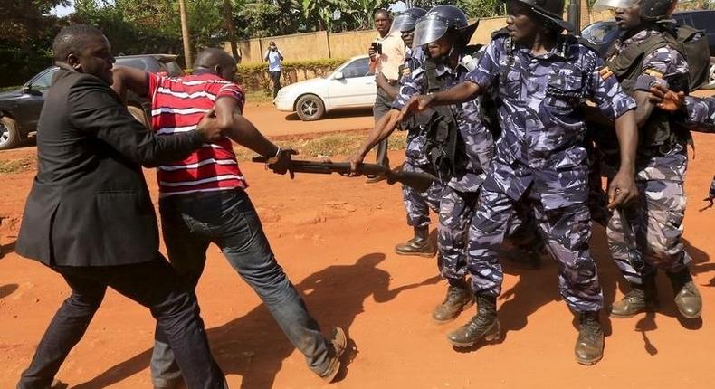 A supporter of Uganda's former Prime Minister Amama Mbabazi wrestles with the gun of a policeman, as riot police disperse a gathering in Jinja town in eastern Uganda September 10, 2015.  REUTERS/James Akena