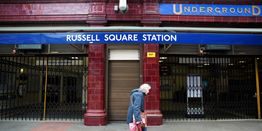 FILE PHOTO - A woman walks past a closed entrance of Russell Square underground station in London April 29, 2014.