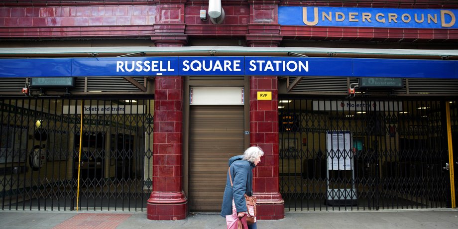 FILE PHOTO - A woman walks past a closed entrance of Russell Square underground station in London April 29, 2014.