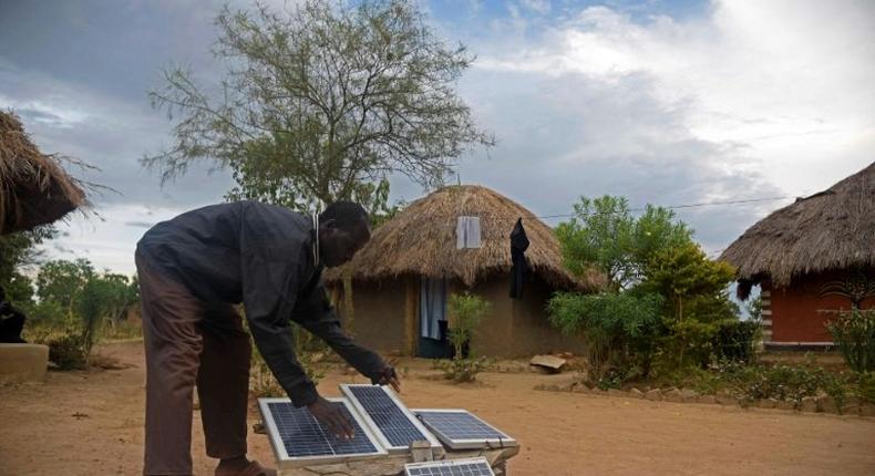 Robert Otala checks on solar panels that he uses for his home in Soroti District about 300 kilometres northeast of the capital Kampala