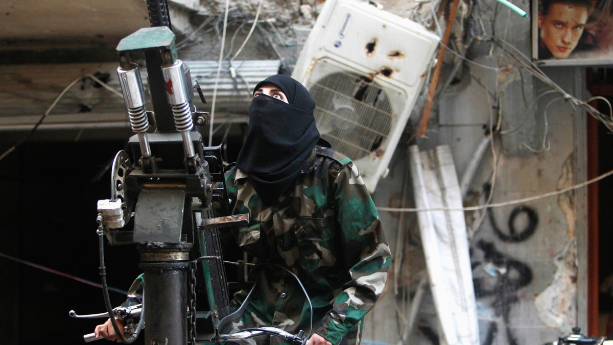 A female member of the Ahbab Al-Mustafa Battalion stands on a pick-up truck mounted with an anti-air