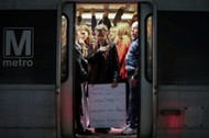 A woman activist holds placard on Metrorail on way to Women's March in Washington, D.C.