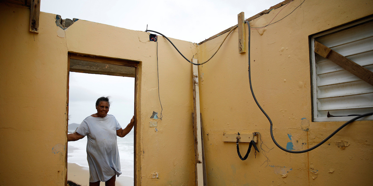 Irma Torres stands in the doorway of her roofless home after Hurricane Maria in Yabucoa, Puerto Rico.