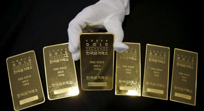 An employee poses for photographs with gold bars at the Korea Gold Exchange in Seoul, South Korea, July 31, 2015. REUTERS/Kim Hong-Ji/Files