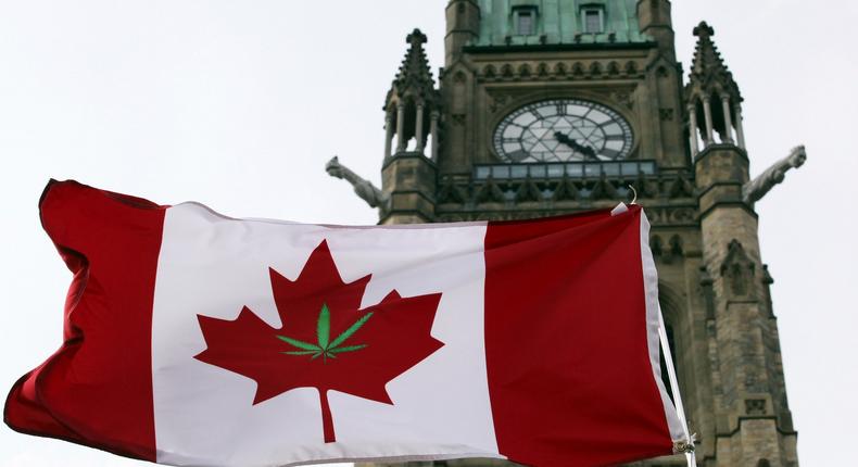 A Canadian flag emblazoned with a marijuana leaf flies at a legalization rally outside the countries parliament.