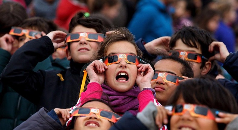 Children use special glasses to look into the sky during a partial solar eclipse outside the Planetario on March 20, 2015 in Madrid, Spain.