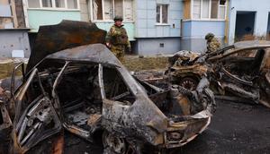 Russian soldiers standing by burned-out cars in Belgorod following aerial attacks on March 22, 2024.STRINGER/AFP via Getty Images