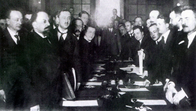 Podpisanie traktatu ryskiego. Leonid Obolenski stoi pierwszy od lewej (domena publiczna)