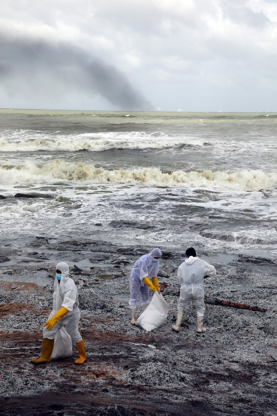 Personel marynarki wojennej Sri Lanki w odzieży ochronnej usuwający odpady i granulki chemiczne używane do produkcji plastiku, wyrzucone na brzeg z płonącego statku towarowego MV X-Press Pearl na plażach Wattala do Negombo na przedmieściach Kolombo na Sri Lance.