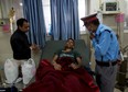 Rishi Khanal, 28, who was pulled out from a collapsed residential building following Saturday's earthquake, speaks to a security guard at a hospital in Kathmandu