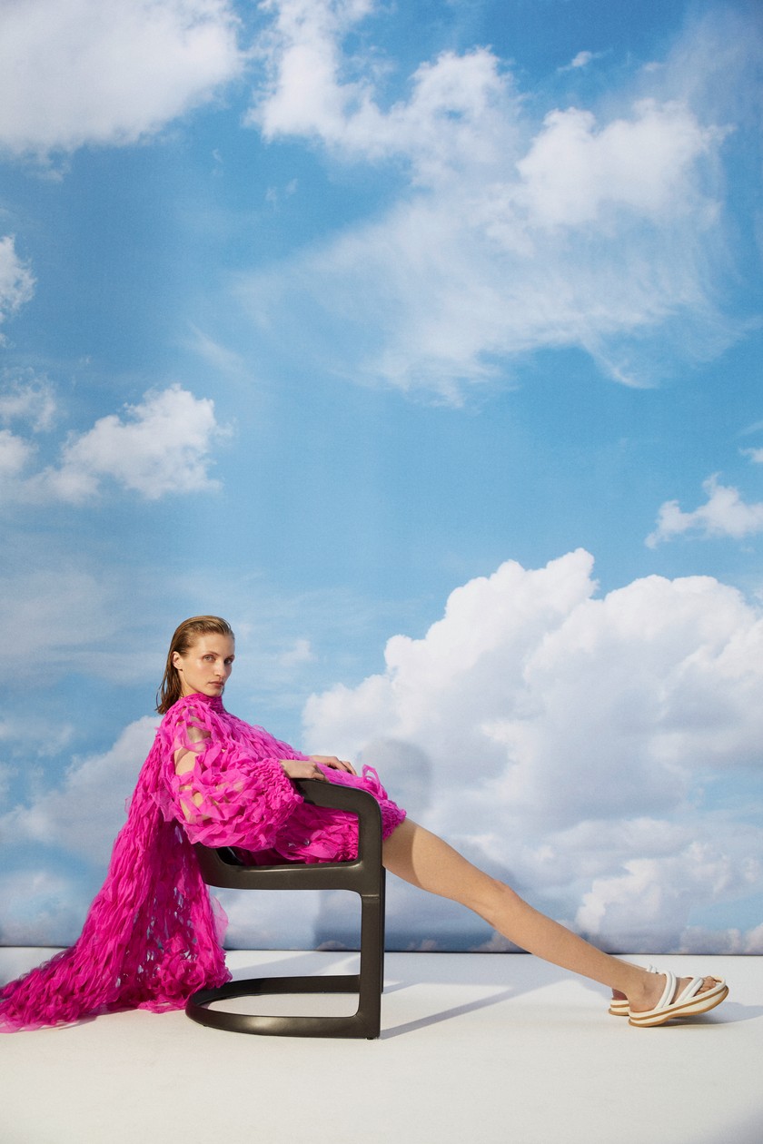 DRIES VAN NOTEN Oversize-Pullover und Schal, beides aus gerissener Seidenorganza. Plateausandalen aus Leder. Minotti Stuhl Twombly mit Lederbezug im Farbton Mokka.