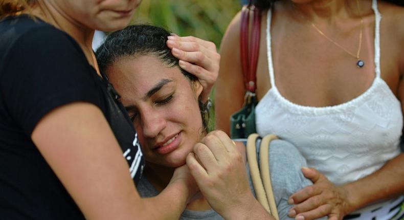 A woman is comforted after two buildings collapsed in the Muzema favela of Rio de Janeiro, Brazil, on April 12, 2019