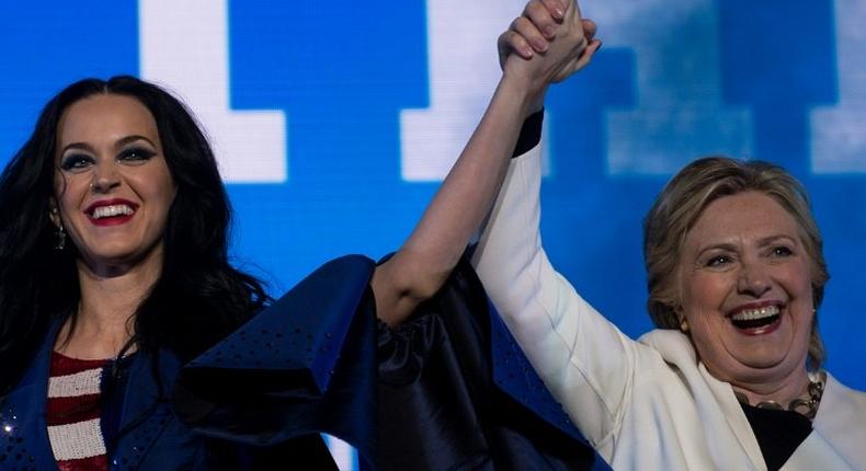 Singer Katy Perry (L) and Democratic presidential nominee Hillary Clinton cheer during a GOTV concert in Philadelphia, Pennsylvania